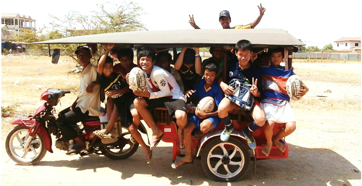 Group of young boys in a tuktuk with rugby balls